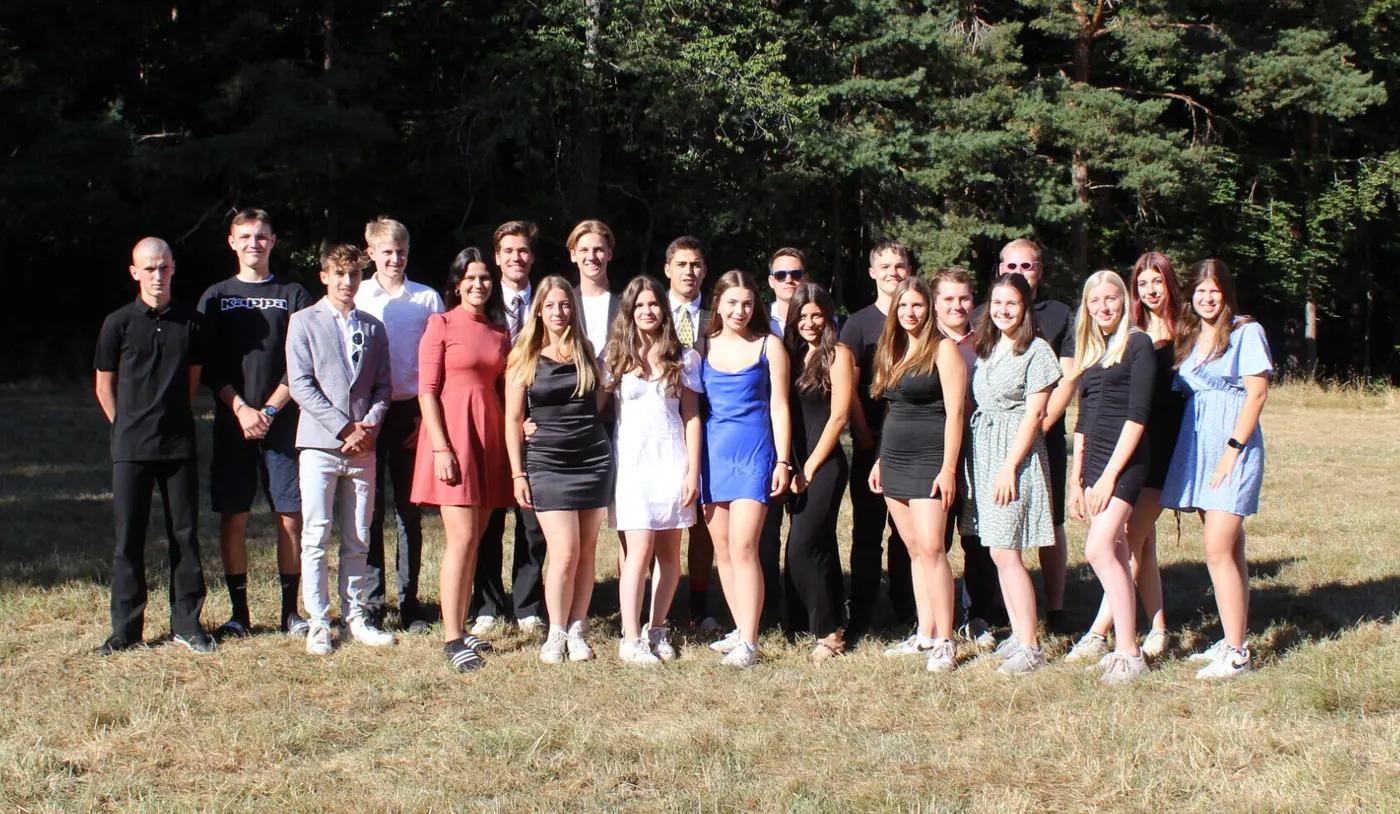 Gruppenfoto der Gruppenleiterinnen und Gruppenleiter vor einem Wald